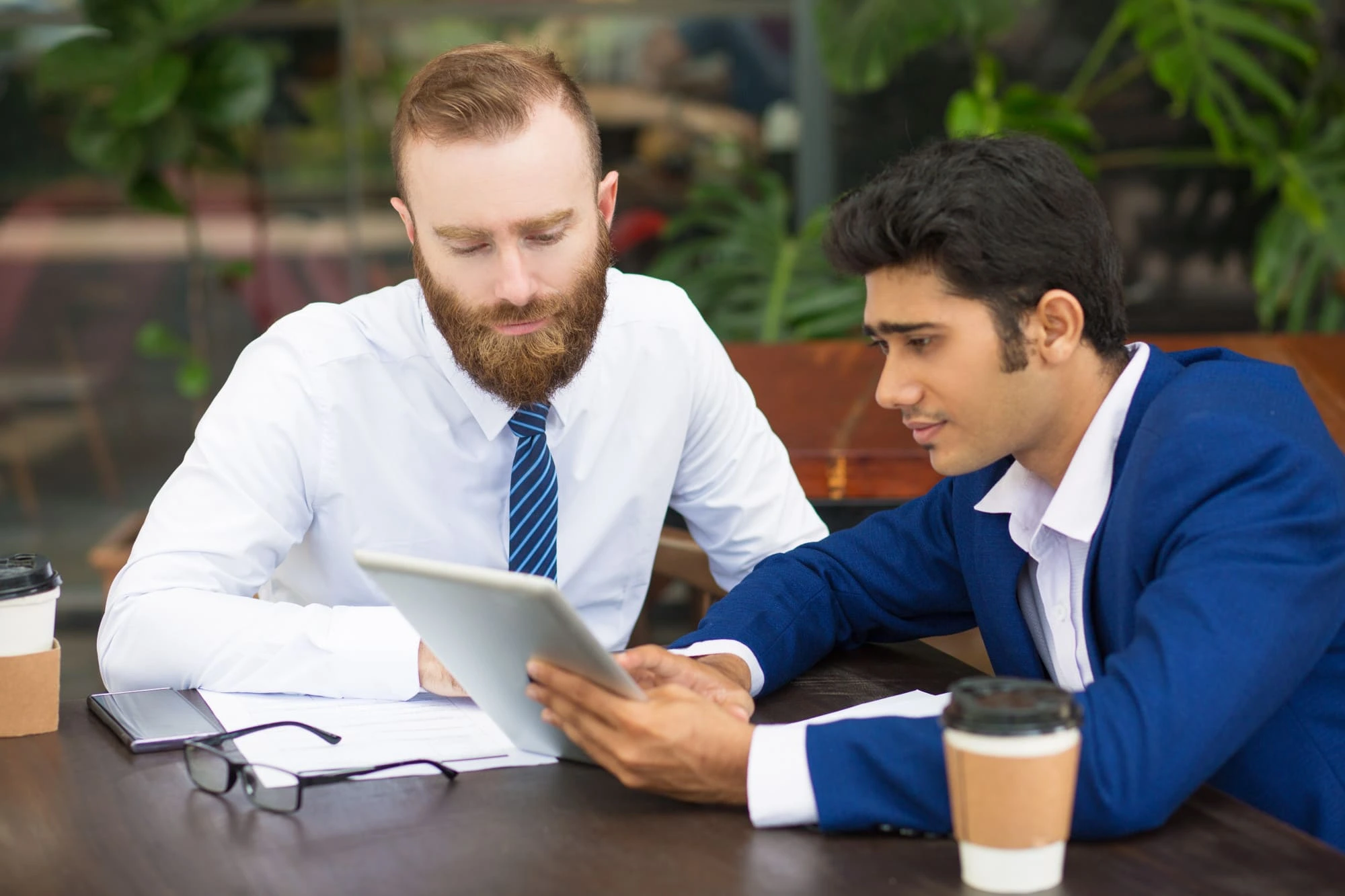 pensive-colleagues-using-modern-device-while-taking-statistics