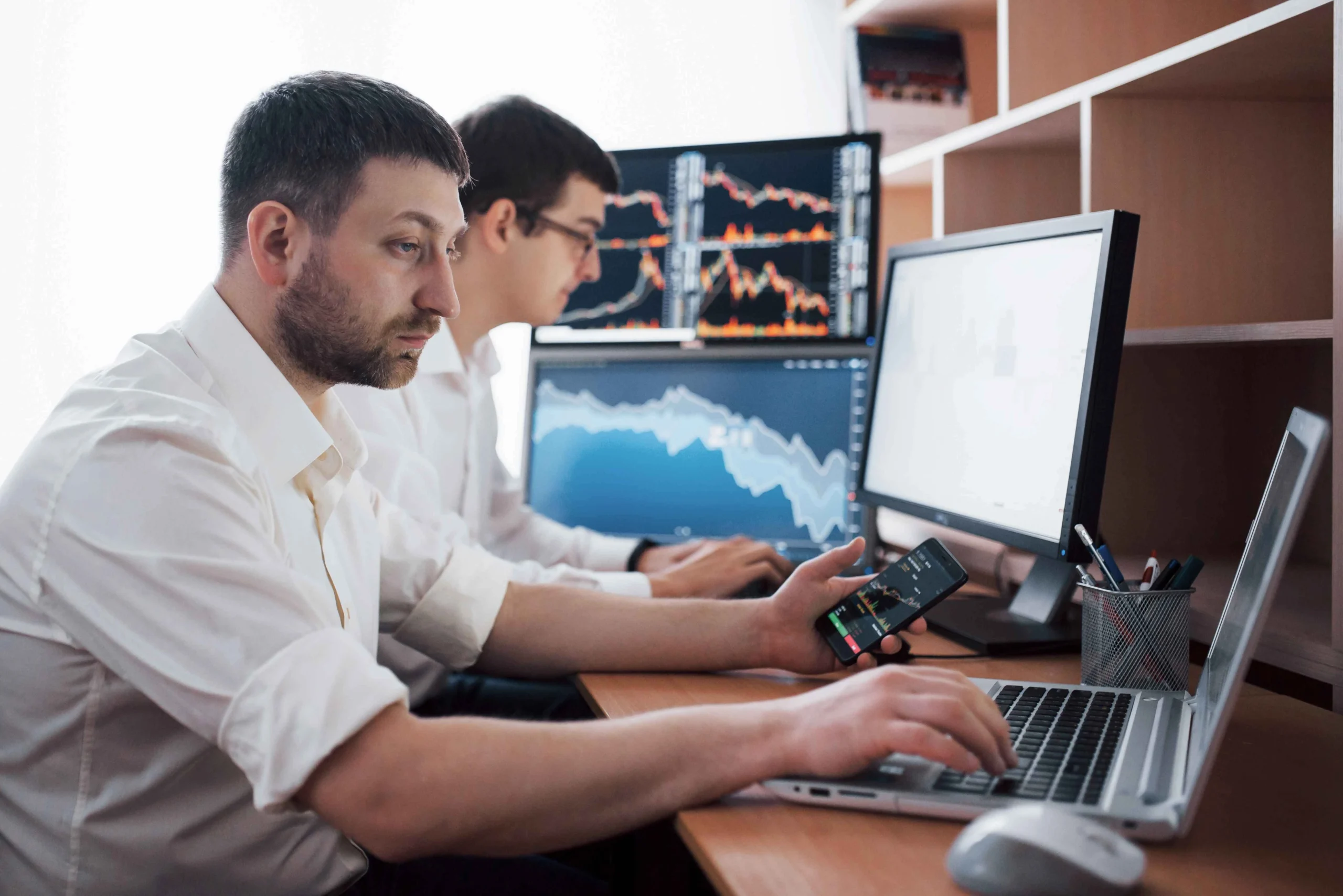 team-stockbrokers-are-having-conversation-dark-office-with-display-screens-analyzing-data-graphs-reports-investment-purposes-creative-teamwork-traders (1)